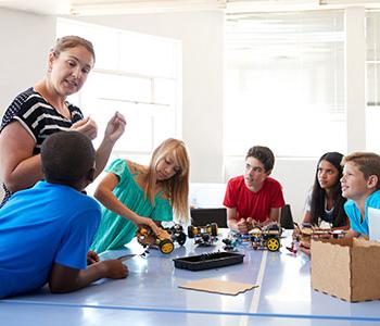 Teacher demonstrating program to five students.